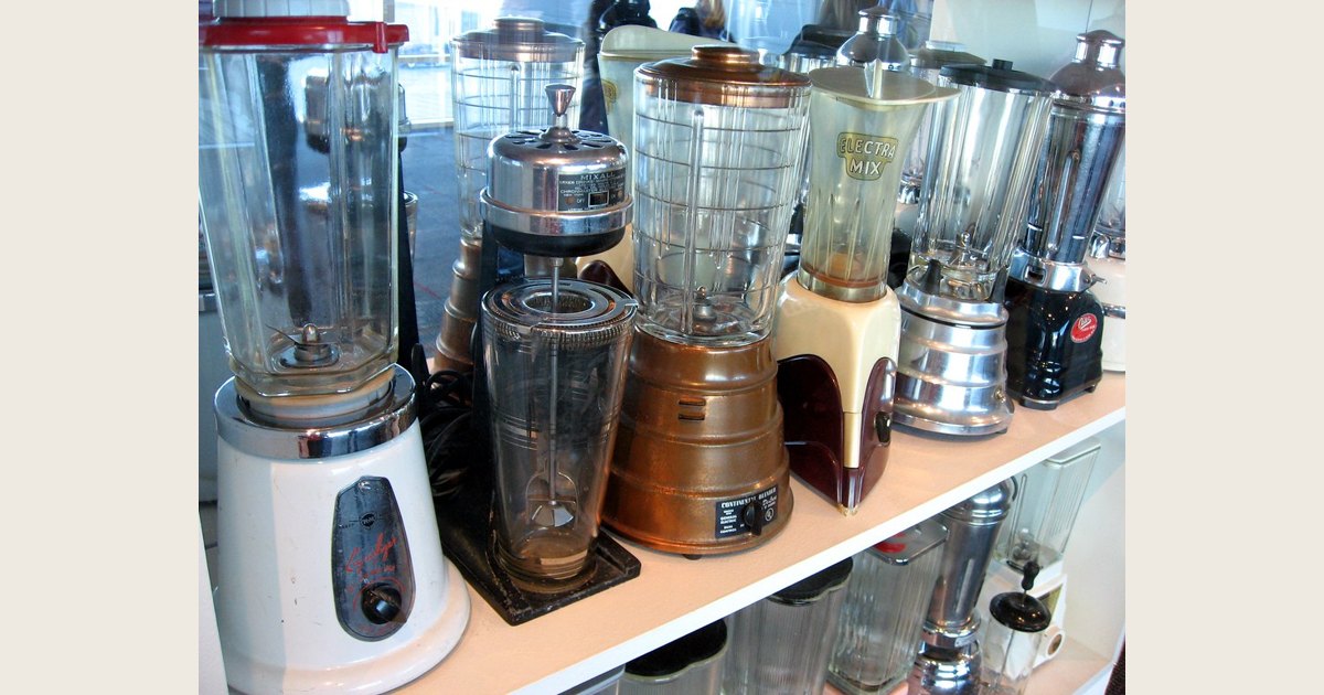 Several countertop blenders and jars arranged together on a counter.